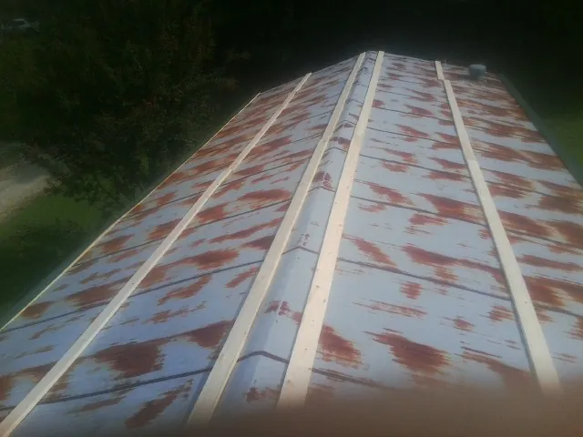 Rusted metal roof panels with new wood purlins before replacement — Storm Damage Roof Repair in Marianna by Roofing Brothers